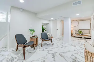 a living room with two chairs and a marble floor at Farmhouse Fresh 4BR Retreat in University Heights