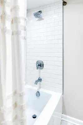 a white bath tub with a shower curtain in a bathroom at Farmhouse Fresh 4BR Retreat in University Heights