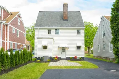 a white house with a chimney on top at Farmhouse Fresh 4BR Retreat in University Heights
