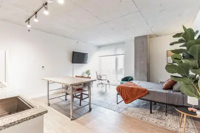 a living room with a couch and a table at 2 New Studios with Stunning City Views in Cleveland