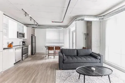 a living room with a couch and a table at 10 Brand new combined apartments with city views in Cleveland