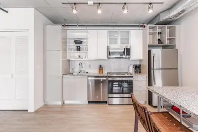 a kitchen with white cabinets and stainless steel appliances at 4BR Combined Units at Skyline 776 in Cleveland
