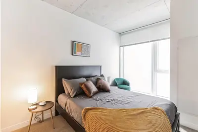 a bedroom with a bed and a chair and a window at 3 Brand new combined apartments with city views in Cleveland