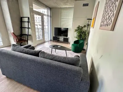 a living room with a couch and a table at 3 Brand new combined apartments with city views in Cleveland