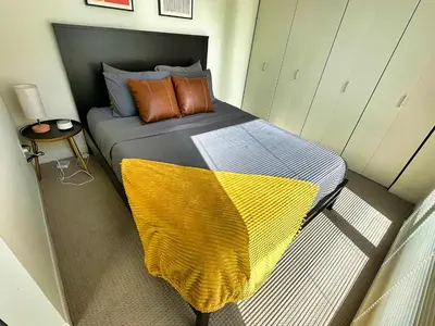 a bedroom with a bed with a yellow blanket on it at 3 Brand new combined apartments with city views in Cleveland