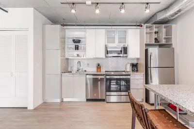 a kitchen with white cabinets and stainless steel appliances at 5 Brand new combined apartments with city views in Cleveland