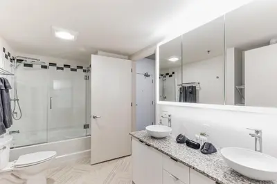 a white bathroom with two sinks and a shower at 5 Brand new combined apartments with city views in Cleveland