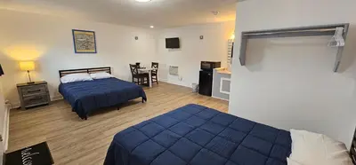 a bedroom with two beds and a table with a chair at Sunrise Inn LLC in Port Clinton