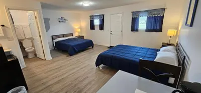 a hotel room with two beds and a bathroom at Sunrise Inn LLC in Port Clinton