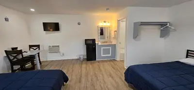 a bedroom with two beds and a table and a kitchen at Sunrise Inn LLC in Port Clinton