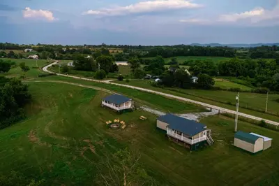 an aerial view of a large green field with two cottages at Rustic Mt Sterling Cabin2 Near Downtown Pets OK in Mount Sterling