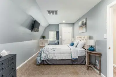 a bedroom with a bed and a table with a lamp at The Mad Cat Inn in Lewis Center