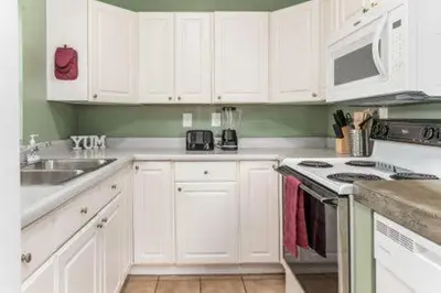 a kitchen with white cabinets and a stove top oven at The Mad Cat Inn in Lewis Center