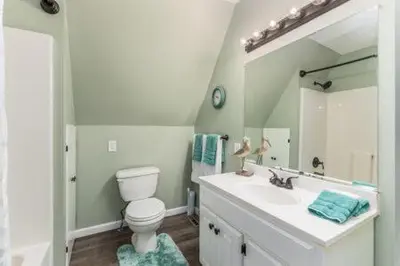a bathroom with a toilet and a sink and a mirror at The Mad Cat Inn in Lewis Center