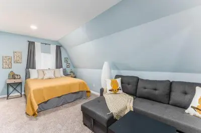a living room with a couch and a bed at The Mad Cat Inn in Lewis Center