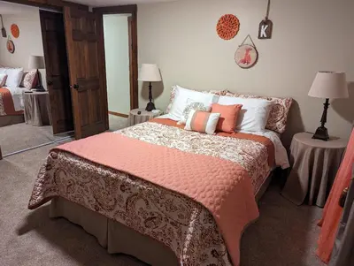 a bedroom with a bed with orange and white pillows at The Lazy Cat Lodge in Lewis Center