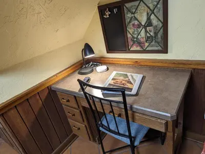 a desk with a lamp and a picture on it at The Lazy Cat Lodge in Lewis Center
