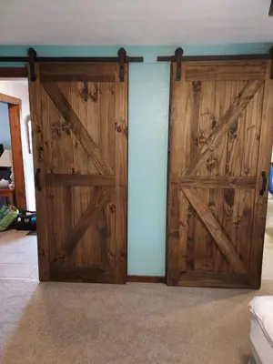 a pair of wooden doors in a room at The Lazy Cat Lodge in Lewis Center