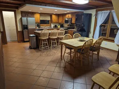 a kitchen with a table and chairs and a refrigerator at The Lazy Cat Lodge in Lewis Center
