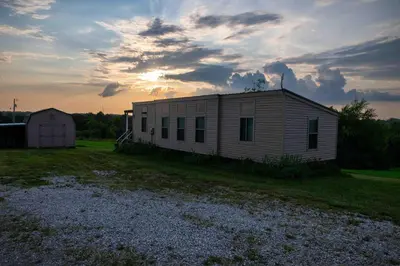 a small house sitting on top of a field at Rustic Mt Sterling Cabin1 Near Downtown Pets OK in Mount Sterling