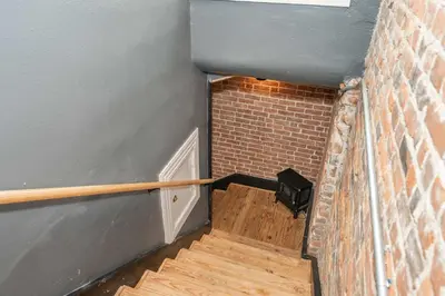 a staircase in a room with a brick wall at The Brick Dachshund - Chic for 9
