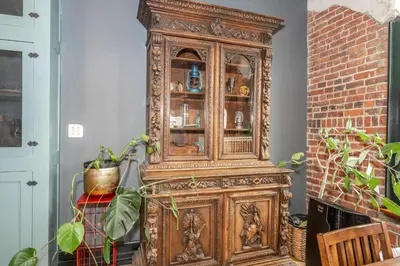 an old wooden cabinet in a room with plants at The Brick Dachshund - Chic for 9