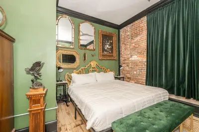 a bedroom with a bed and a green wall at The Brick Dachshund - Chic for 9