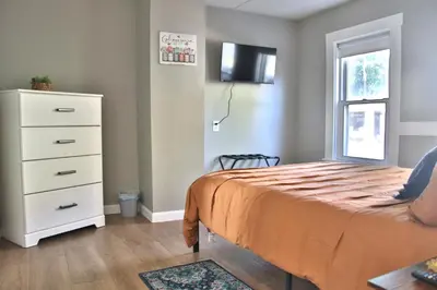 a bedroom with a bed and a dresser and a window at Updated Lakewood Retreat! in Lakewood