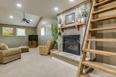a living room with a fireplace and a book shelf at Private Ponds and Trails Hillsboro Nature Retreat! in Hillsboro