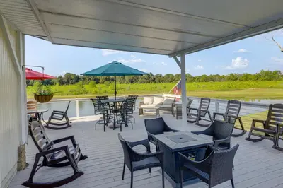 a deck with chairs and tables and an umbrella at Private Ponds and Trails Hillsboro Nature Retreat! in Hillsboro