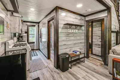a kitchen in a tiny house with wooden walls at Ohio Amish Country Getaway Fish, Hike, Boat! in Sugarcreek