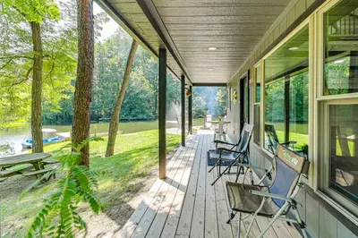 a porch with chairs and tables and a view of a lake at Ohio Amish Country Getaway Fish, Hike, Boat! in Sugarcreek