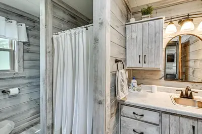 a bathroom with a shower curtain and a sink at Ohio Amish Country Getaway Fish, Hike, Boat! in Sugarcreek