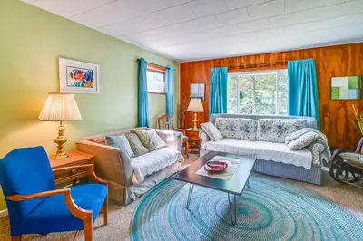 a living room with a couch and a table at Boat and Unwind! Charming Atwood Lake Farmhouse in Dellroy