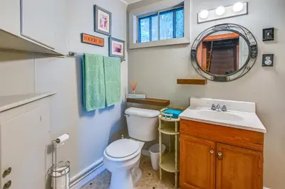 a bathroom with a toilet and a sink and a mirror at Boat and Unwind! Charming Atwood Lake Farmhouse in Dellroy