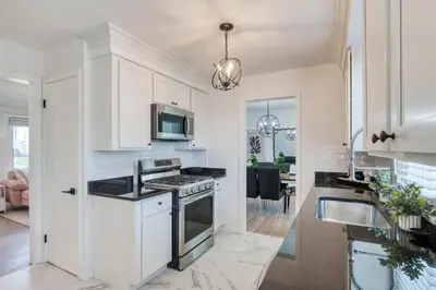 a kitchen with white cabinets and a stove top oven at Stylish 3BR w Sunroom & Deck in Cleveland