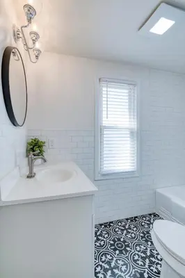 a white bathroom with a sink and a mirror at Stylish 3BR w Sunroom & Deck in Cleveland