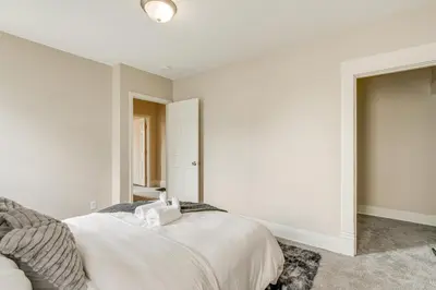 a bedroom with white walls and a large bed at 6 Mi to Ohio State Walkable Home in S Columbus! in Columbus