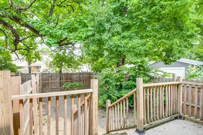 a wooden fence in a yard with a tree at 6 Mi to Ohio State Walkable Home in S Columbus! in Columbus
