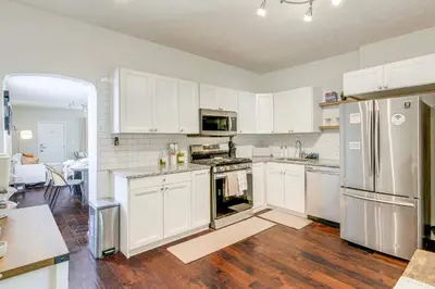 a kitchen with white cabinets and stainless steel appliances at 6 Mi to Ohio State Walkable Home in S Columbus! in Columbus