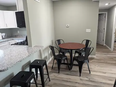 a kitchen with a table and stools in a room at The Calico Cottage in Lewis Center