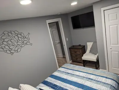 a bedroom with a bed and a tv on the wall at The Calico Cottage in Lewis Center