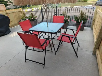 four chairs and a table with a blue table and red chairs at The Calico Cottage in Lewis Center