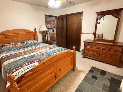 a bedroom with a large wooden bed and a dresser at Whispering Pines Auburn in Auburn