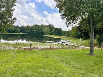 a view of a river with a boat in a field at Whispering Pines Auburn in Auburn