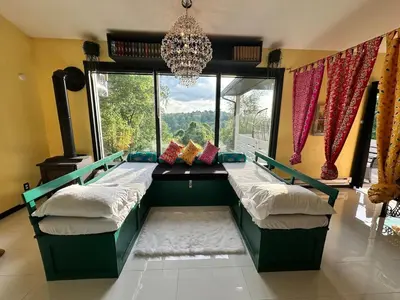 a room with two beds in front of a window at Buddhas Little Cabin! 1 min from Palace of Gold in Moundsville