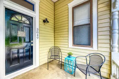 a porch with two chairs and a table next to a door at Riverside Hideaway just outside of downtown Cincy in Cincinnati