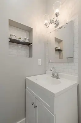 a white bathroom with a sink and a mirror at Riverside Hideaway just outside of downtown Cincy in Cincinnati