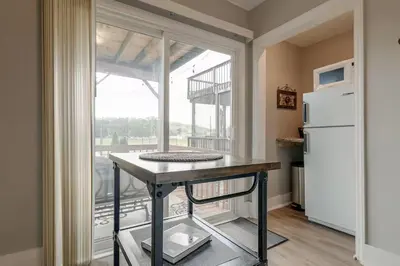 a kitchen with a table and a refrigerator and a window at Riverside Hideaway just outside of downtown Cincy in Cincinnati