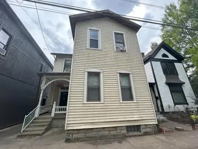 a white house with a front porch and aermottermottermottermott at Riverside Hideaway just outside of downtown Cincy in Cincinnati